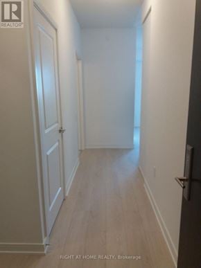 Mississauga (City Centre) condo for rent - A long hallway with white walls and wood floors.