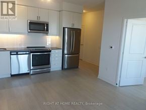 Mississauga (City Centre) condo for rent - A kitchen with a refrigerator, oven, and microwave.