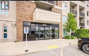 Milton condo for rent - A black car is parked in a parking lot in front of a building with a sign that says REALTOR.
