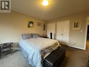 Kitchener townhouse for rent - A bedroom with a bed, nightstand, and a painting on the wall.