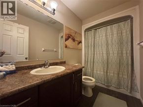 Kitchener townhouse for rent - A bathroom with a sink, toilet, and shower curtain.