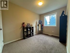 Kitchener townhouse for rent - A room with a carpeted floor, a window, and a bookshelf.