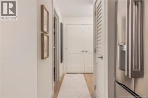 Saint John apartment for rent - A hallway with a white door and a fridge on the side.