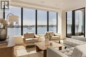 Saint John apartment for rent - A living room with a view of the water and boats outside the large windows.