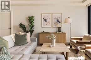 Saint John apartment for rent - A living room with a grey couch, a wooden table, and a painting on the wall.