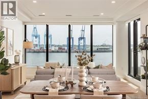 Saint John apartment for rent - A well-lit dining room with a view of the water and cranes outside the window.