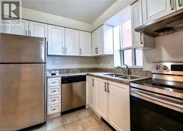 Burlington condo for rent - A kitchen with white cabinets and stainless steel appliances.
