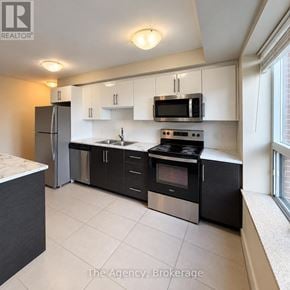 St. Catharines (Downtown) multi-family for rent - A kitchen with black appliances and white cabinets.