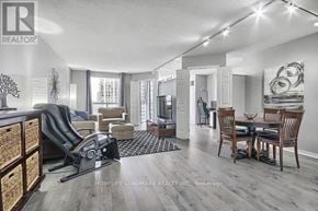 Toronto (Banbury-Don Mills) condo for rent - A well-lit living room with a dining area and a kitchen in the background.