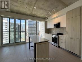 Toronto (Church-Yonge Corridor) condo for rent - A modern kitchen with wooden cabinets and a large island.