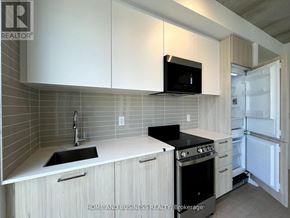 Toronto (Church-Yonge Corridor) condo for rent - A kitchen with white cabinets and a black microwave.
