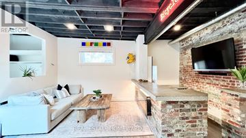 Toronto (South Riverdale) apartment for rent - A living room with a white couch and a brick wall.