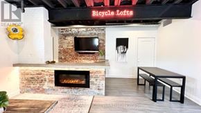 Toronto (South Riverdale) apartment for rent - A room with a brick fireplace and a sign that says "Bicycle Lofts".