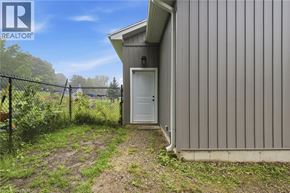 St. Agatha apartment for rent - A small building with a white door is surrounded by a fence and vegetation.