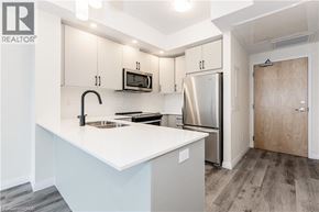 Kitchener condo for rent - A kitchen with a white counter top and stainless steel appliances.