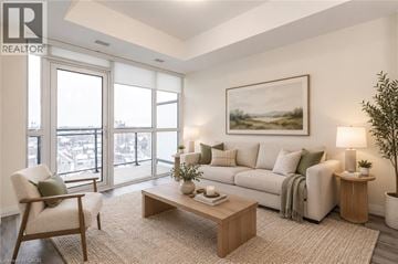 Kitchener condo for rent - A living room with a couch, chair, and a painting on the wall.