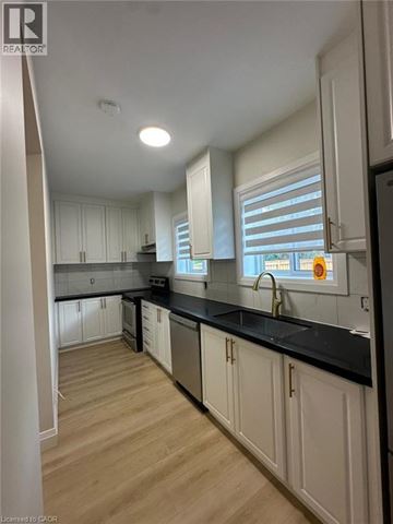 Hamilton apartment for rent - A kitchen with white cabinets and black countertops.