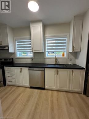 Hamilton apartment for rent - A kitchen with white cabinets and a black countertop.
