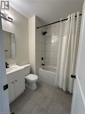 Hamilton apartment for rent - A white bathroom with a toilet, sink, and bathtub.
