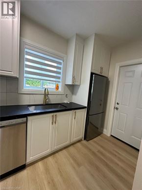 Hamilton apartment for rent - A kitchen with white cabinets and a black countertop.