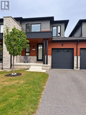 Wasaga Beach townhouse for rent - A modern house with a black garage door.
