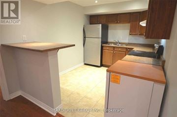 Brampton (Fletcher's Meadow) apartment for rent - A kitchen with a refrigerator, counter, and cabinets.