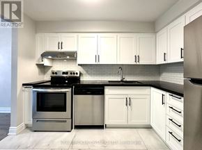 Mississauga (Applewood) townhouse for rent - A modern kitchen with white cabinets and black countertops.