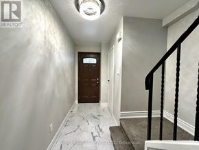 Mississauga (Applewood) townhouse for rent - A hallway with a black railing and a brown door.