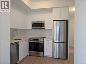 Kitchener condo for rent - A kitchen with white cabinets and stainless steel appliances.