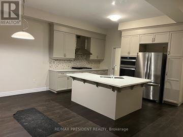 Hamilton (Stoney Creek Mountain) apartment for rent - A kitchen with a large island in the middle and a refrigerator to the right.