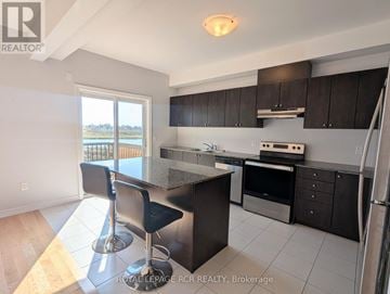 Southgate townhouse for rent - A kitchen with black cabinets and a wooden floor.