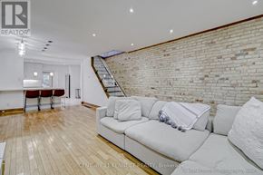 Toronto (East End-Danforth) apartment for rent - A living room with a white couch and a brick wall.