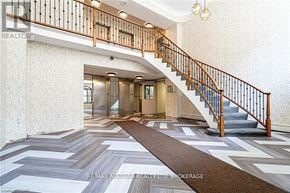 St. Catharines (Fairview) condo for rent - A hallway with a staircase and a patterned floor.