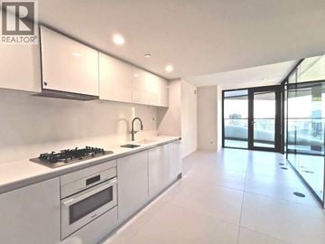 Vancouver apartment for rent - A modern kitchen with white cabinets and a gas stove.