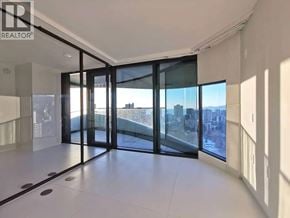 Vancouver apartment for rent - A spacious room with a view of the city through large windows.