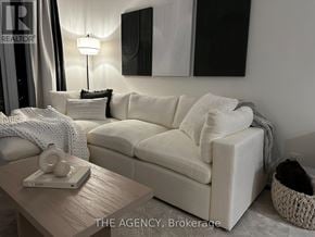Toronto (Wychwood) condo for rent - A white couch with a grey throw blanket on it.
