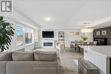 Barrie (Innis-Shore) condo for rent - A modern living room with a grey sofa and a white coffee table.