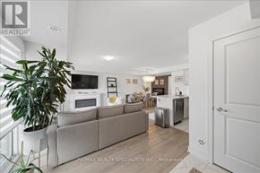 Barrie (Innis-Shore) condo for rent - A living room with a couch, a television, and a plant.