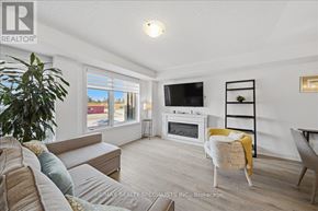 Barrie (Innis-Shore) condo for rent - A living room with a couch, chair, and television.
