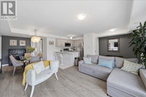 Barrie (Innis-Shore) condo for rent - A living room with a grey couch and a white chair.