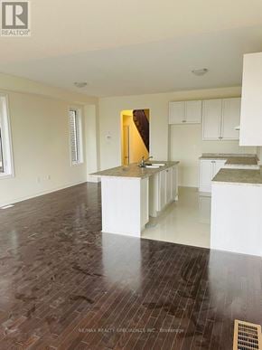 Brampton (Northwest Brampton) townhouse for rent - A large, empty room with wooden floors and white walls.