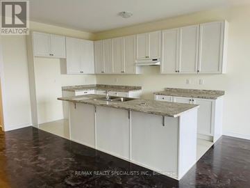 Brampton (Northwest Brampton) townhouse for rent - A kitchen with white cabinets and a granite countertop.