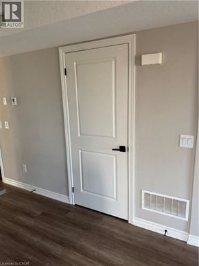 Kitchener apartment for rent - A white door is in a room with wood flooring.