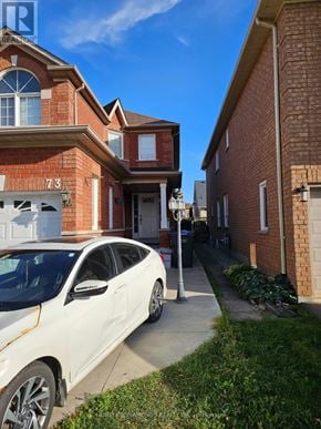 Brampton (Northwest Sandalwood Parkway) apartment for rent - A white car is parked in front of a house with the number 73 on it.