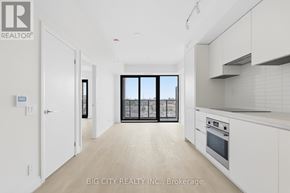 Toronto (Leaside) condo for rent - A white kitchen with a sliding glass door leading to a balcony.