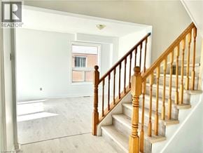 Grimsby apartment for rent - A wooden staircase leads up to a window in a white room.