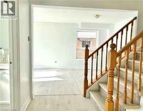 Grimsby apartment for rent - A wooden staircase leads up to a window in a white room.