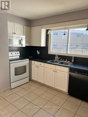 Niagara Falls (Morrison) apartment for rent - A kitchen with black countertops and white appliances.