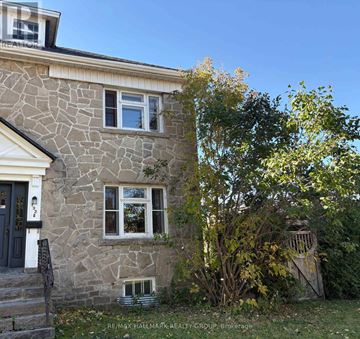 Ottawa apartment for rent - A stone house with a black door and a small window.