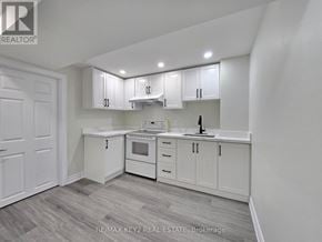 Whitby (Williamsburg) apartment for rent - A white kitchen with a grey floor and a white door.